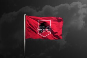 A red flag waves on a flagpole against a cloudy sky, featuring striking designer creative direction—a logo with a lion, the words CROSSFIT INDOMABLE, geometric shapes, and the year 1983 in white and black. - FelipeIgiesias.com